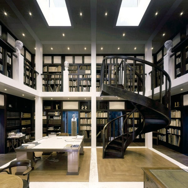 Abgedunkeltes Bibliotheksinterior mit Treppe und Bücherregalen, inspirierendes Lernumfeld.